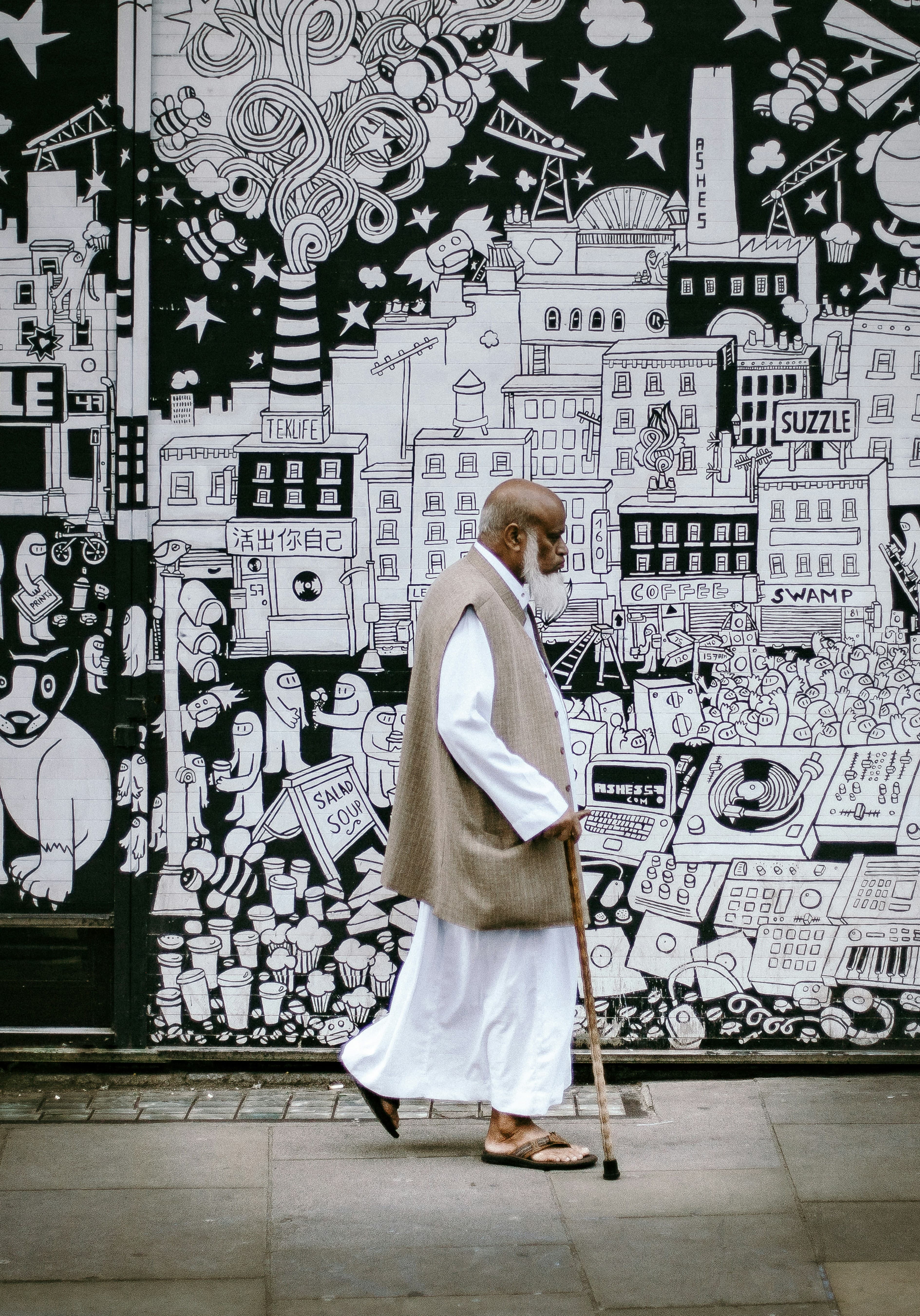 A pedestrian passing a dense black-and-white mural