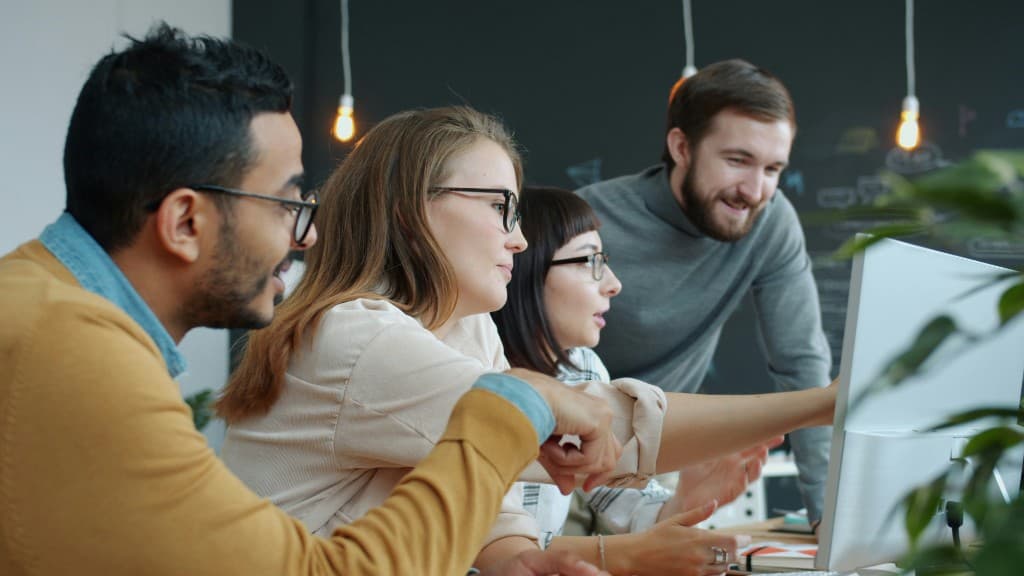 A team working together around screens in a bright studio